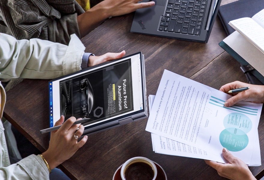 Lenovo ThinkPad X1 Yoga Gen 8 2-in-1 laptop in tent mode next to a wireless keyboard, being used with the integrated pen.